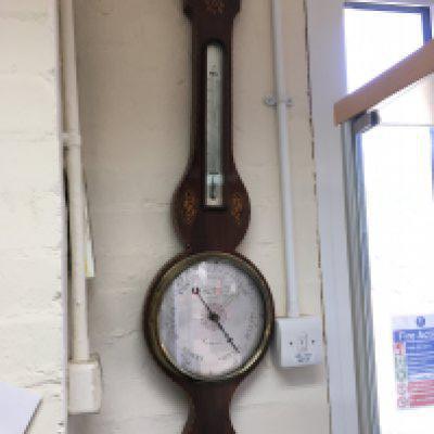 An inlaid mahogany wall barometer. Shipping category D.