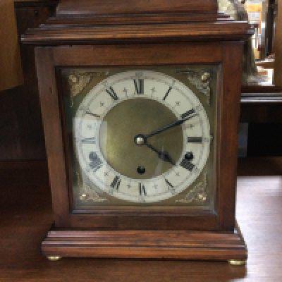 A mahogany mantle clock the dial with Roman numerals.