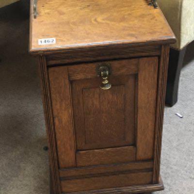 A carved oak coal box with a hinged front brass gallery and shovel.
