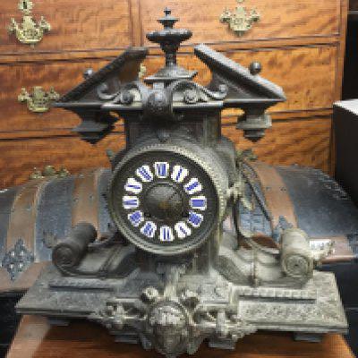 A French late 19th century mantel clock with shaped top and scrolls raised mask the movement striking on a bell with pendulum not seen working. Hight 35cm
