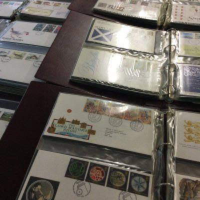 Six red albums containing first day covers.