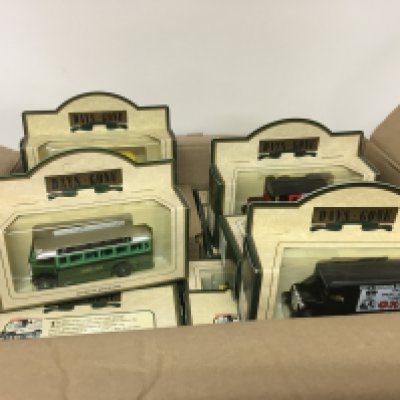 Two boxes full of Days Gone and Burago scale models die-cast cars and other boxed conforming vehicles. (2)