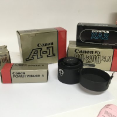 A boxed as new Canon A1 Camera with two boxed Canon Lens 80-200 Zoom and 50/1.4 a canon winder A a boxed Olympus XA2 and a Nikon 24mm 1:2.8.