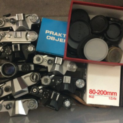 Four boxes containing various cameras and lenses.