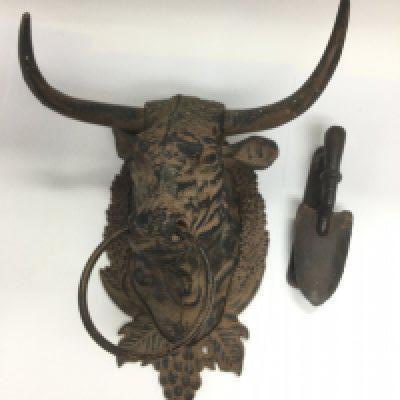 A cast metal wall mounted bull's head and a novelty door knocker in the form of a trowel (2). Shipping category D.