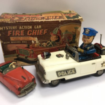 Two tin plate toy cars comprising a battery operated police car in a Fire Chief box plus a Schuco tin plate car (2). Shipping category B.