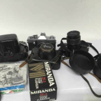 A Vintage Petri camera a 35mm Yashica camera and other camera accessories.