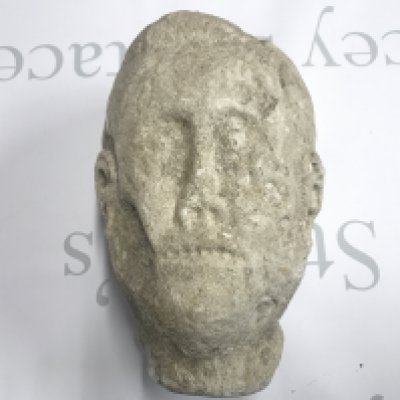 A unique 17th century carved stone sculpture of a gargoyle type head with human features believed to be from Neath Abbey. Approx 28cm by 19cm Postage D