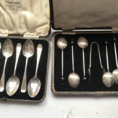 Three cased silver tea / coffee spoons and two cased silver spoons.