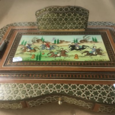 A Indian inlaid desk stand decorated with figures on horse back .