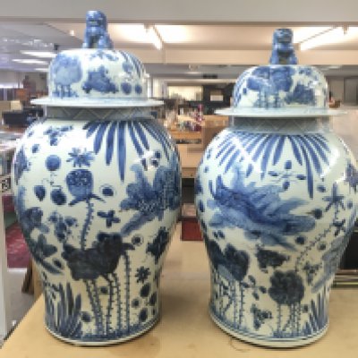 A pair of large Chinese vases with foo dog / lions on the lid. Repair visible to the rim of one. Approximately 70cm tall and 35cm wide. NO RESERVE