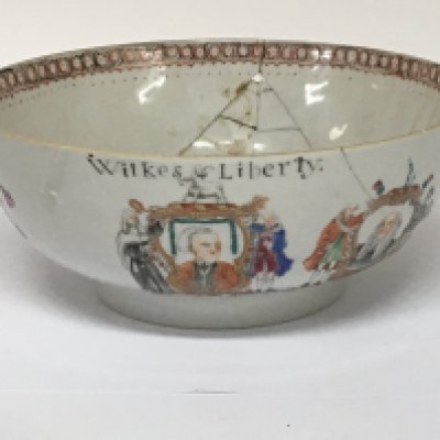A RARE FAMILLE ROSE 'LIBERTY' PUNCH BOWL 18th Century Qianlong with a cartouche portrait of John Wilkes below the inscription Wilkes & Liberty , beside a portrait of Lord Mansfield, each portrait flanked by supporting figures and mottos.26cm (10 1/4in) diam. Footnotes:For a similar bowl see D. S. Howard, Chinese Armorial Porcelain, 1974, p. 955 where the author points out that these bowls, are more political than heraldic. John Wilkes (1725-1797) was a popular campaigner for liberty and was elected to Parliament on several occasions, as well as elected Mayor of London in 1774. Lord Mansfield, representing 'The Establishment', was Lord Chief Justice from 1756-1788 the bowl damaged with cracks.