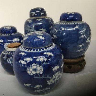 A collection of five Chinese late 19th century export porcelain blue and white ginger jars four with covers one with a hardwood stand. No obvious damage.