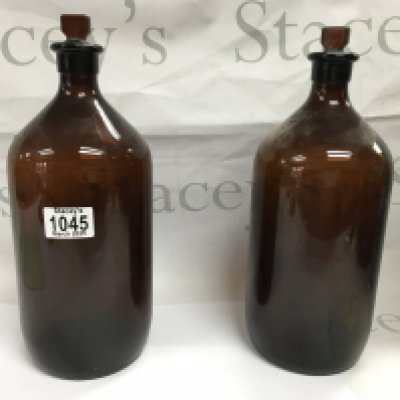 Two large glass bottles and two pottery items with a bags of pipes.