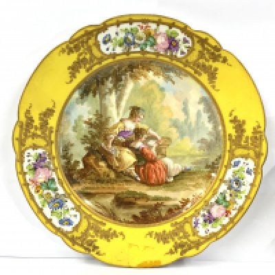 A 19th century Sevres Chateau des Tuileries porcelain cabinet plate, circa 1840s, with yellow border the centre hand decorated with 2 ladies reading, signed 'Watteau', with stamps to underside, 24cm diameter. (D) no viable damage or restoration.