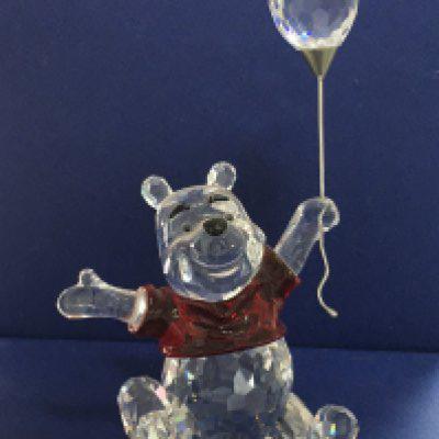 A Swarovski boxed Winnie The Pooh figure, together with five smaller boxed bears including two from the lovely&rsquo;s series, all holding items including flowers, cake and heart. With Certificate of Authenticity. No obvious damage or restoration
