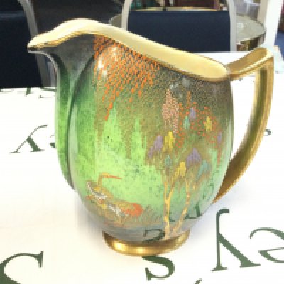 A Carlton ware Vert Royale jug, the body depicting cranes and trees .no obvious damage or restoration. Some fading to the gilt. 18Cm tall approximately. this lot cannot be posted.
