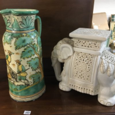 A ceramic elephant seat, a large continental ceramic jug and a wall plaque decorated with sailing ships.
