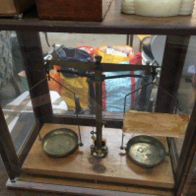 A set of balance scales together with boxed weights and a ball clock .