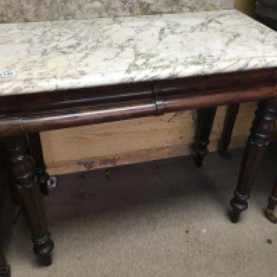 A marble top wash stand fitted with two drawers on fluted legs .
