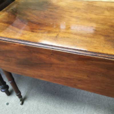 A Georgian mahogany drop leaf table the twin flap top above turned legs .