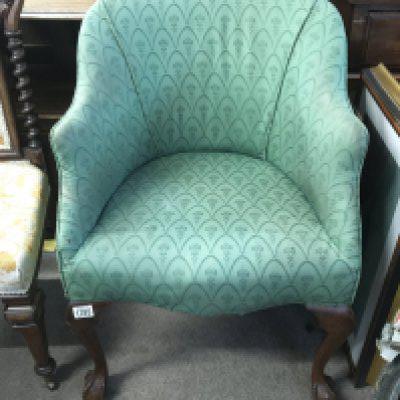 An upholstery mahogany chair with ball and claw feet.
