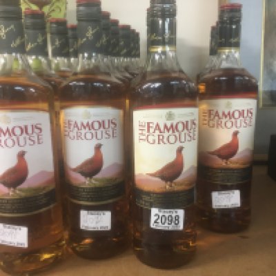 A collection of 22 bottles of famous Grouse whiskey.