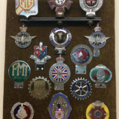 A mounted display of vintage car badges including some rare examples. Shipping category C.