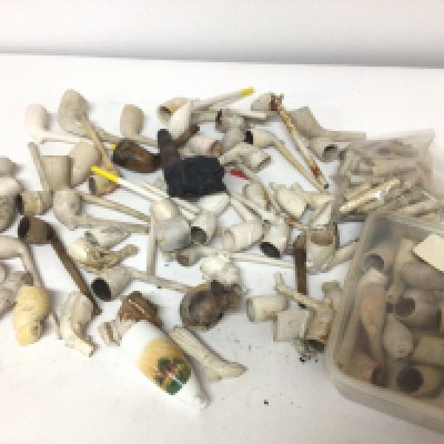 A large collection of antique clay pipes and fragments.
