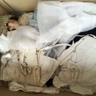 A box containing lace ware various including clothing and table clothes.