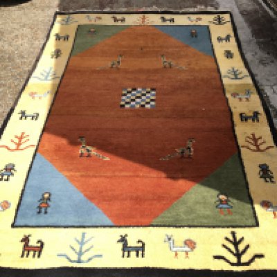 A large Gabbeh style rug decorated with peacocks and other animals. Dimensions 245x165 approximately