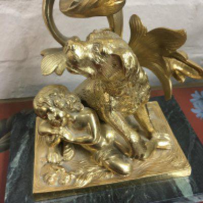 A pair of gilt metal candelabra with glass drops the base in the form of a child with dog on a green marble base . 43 cm .