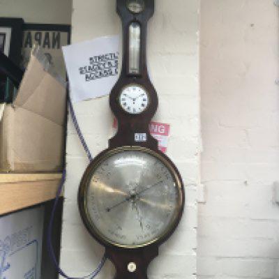 A Georgian mahogany barometer inset with thermometer box and an enamel dial clock