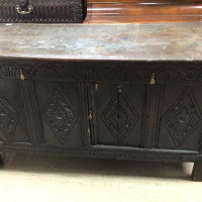 A carved oak 18th century or earlier with carved front and hinged rectangular top. With later later alterations 145cm x 60cm x 80cm