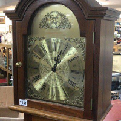 A Mahogany longcase clock with a brass dial and visible brass weights.
