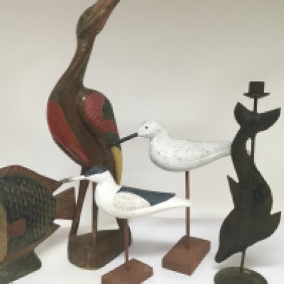 A collection of painted wood models of birds and fish including a metal ornament.