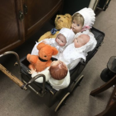 A early 20th century pram with an assortment of vintage dolls and teddies including a Atimand marseille dream baby , E.D Herman Teddy etc. NO RESERVE