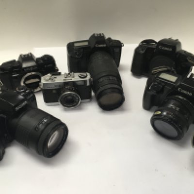 A collection of vintage cameras and camera lenses.