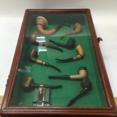 Two cases of various smoking pipes and lighters.