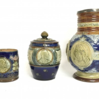 A collection of late 19th/early 20th century Royal Doulton Lambeth Stoneware commemorative ware including a jug with a silver hallmarked collar, 1902 coronation tobacco jar and a 1902 Coronation mug. No obvious damage or restoration