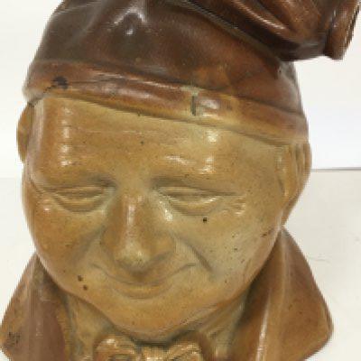 A rare stoneware 19th Century bottle decanter in the form of a large head Souter Johnnie. The top with impressed marks TA Amoss wine and spirit Merchant Bell Mount St Grosvenor Square. Height 26cm hairline cracks.