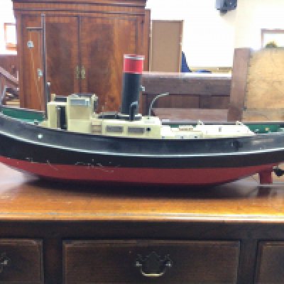 A live steam engine tug boat with boiler. Dimensions 90cm long,23cm wide,44cm tall. This lot cannot. Be posted