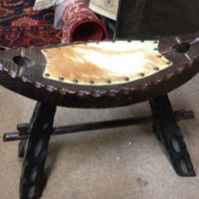 A wooden animal hide stool, 40cm tall, 48cm wide. This lot cannot be posted. NO RESERVE