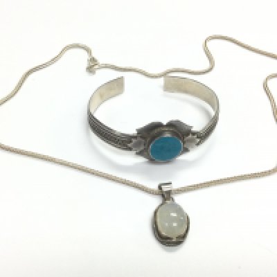 A moonstone pendant on a silver chain and a silver bracelet set with turquoise (2). Shipping category A.- NO RESERVE