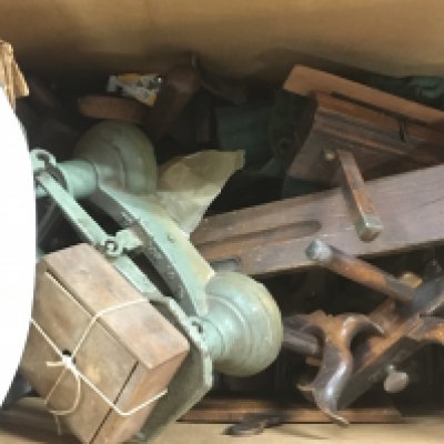 A large collection of vintage woodworking tools including wood planes and a set of scales