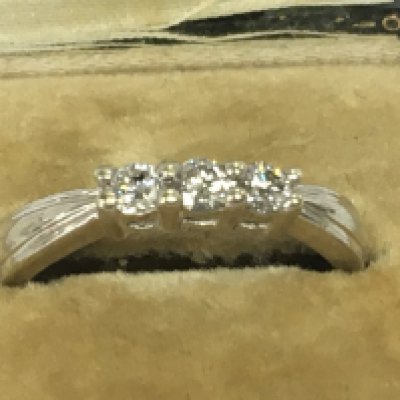 A 9ct white gold ring inset with a row of three diamonds