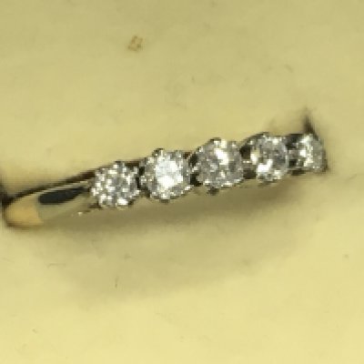 An 18ct gold and platinum ring inset with a row of five diamonds