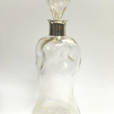 An unusual early 20th century waisted glass decanter and stopper with a hallmarked silver collar