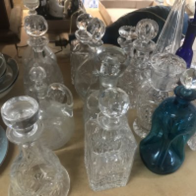 A collection of decanters including some cut glass and coloured glass examples. Approximately 21 decanters.