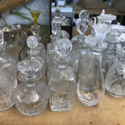 A large collection of decanters including some glass cut and silver plated examples. Approximately 21 decanters.